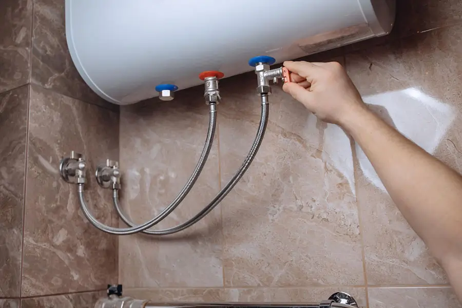 Hand adjusting a valve on a water heater